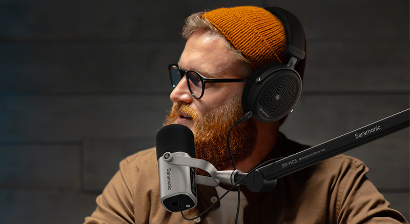 A person using a Saramonic SR-HC5 microphone boom arm with headphones.